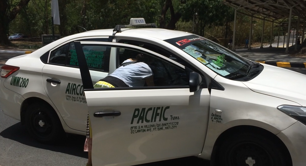 フィリピンのグリーンヒルズへ行くためにタクシーを捕まえている